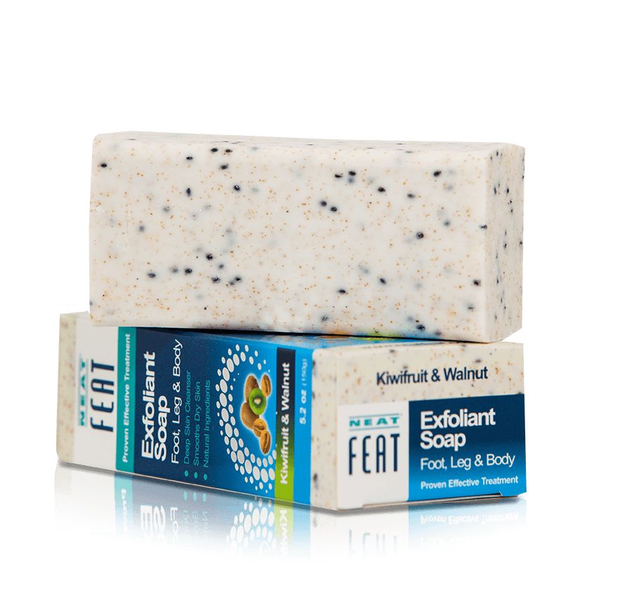 Side shot of Neat Exfoliant Soap 150g Body Scrub, placed on top of the soap in its packaging, showcasing the textured surface with images of kiwi fruit and walnuts on the blue packaging.