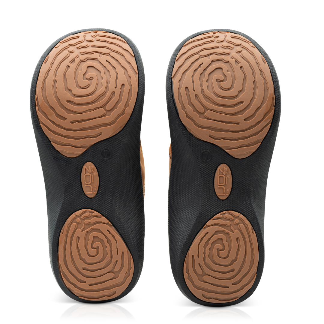 Neat Zori Cognac/Black Orthotic Sandals, both flipped to show their underside, featuring mostly black with brown pads, displayed side by side.