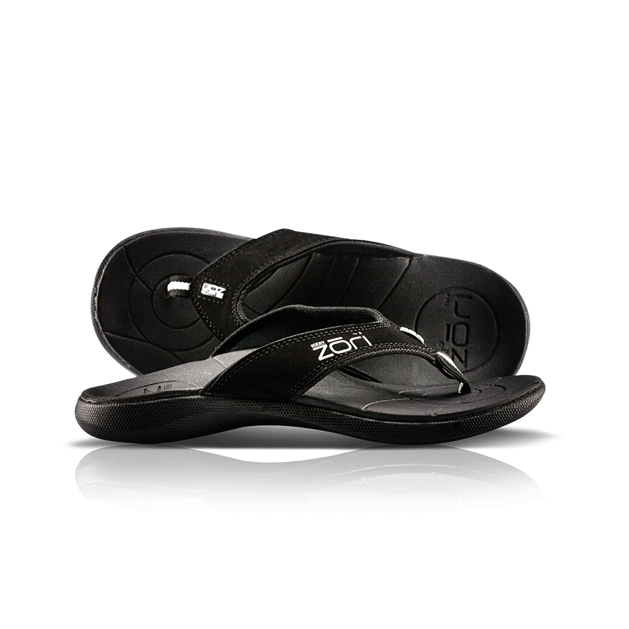 Neat Zori Black Orthotic Thong/Sandal, one lying flat and the other on its side showing the top view, mostly black with white Neat Zori logo.